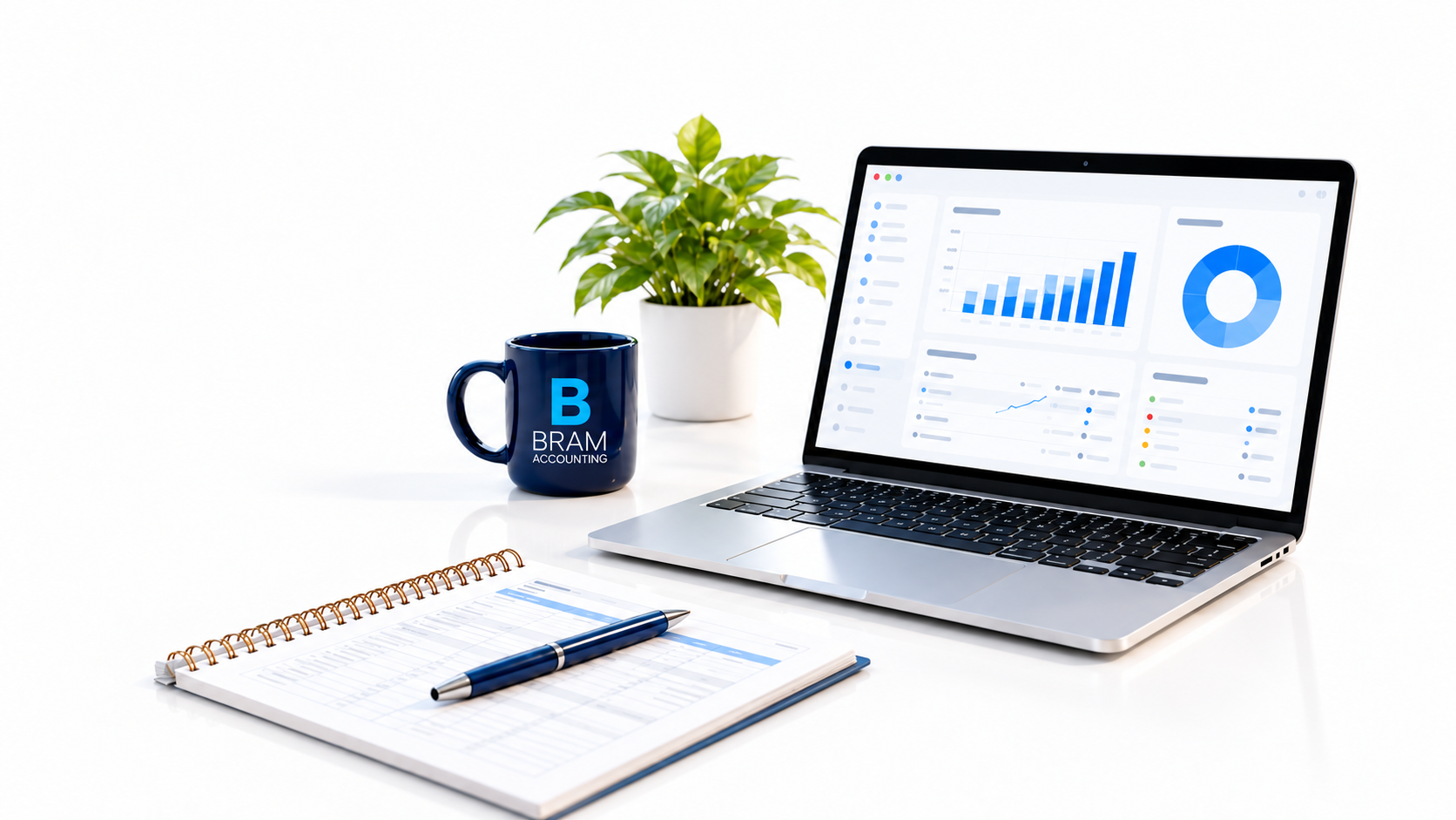 Laptop displaying a bookkeeping dashboard on a bright desk with a navy mug, plant, ledger, and pen